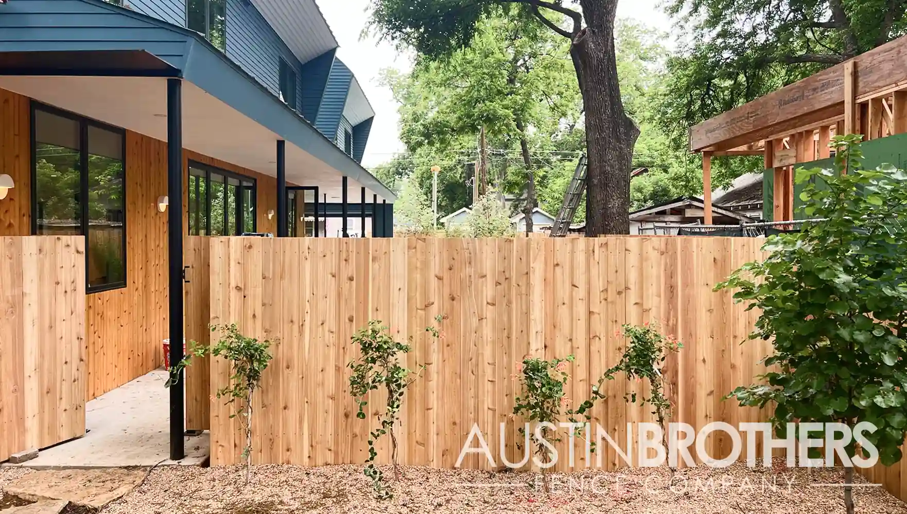 A wooden fence built by Austin Brothers Fence Company beside a modern Austin home.