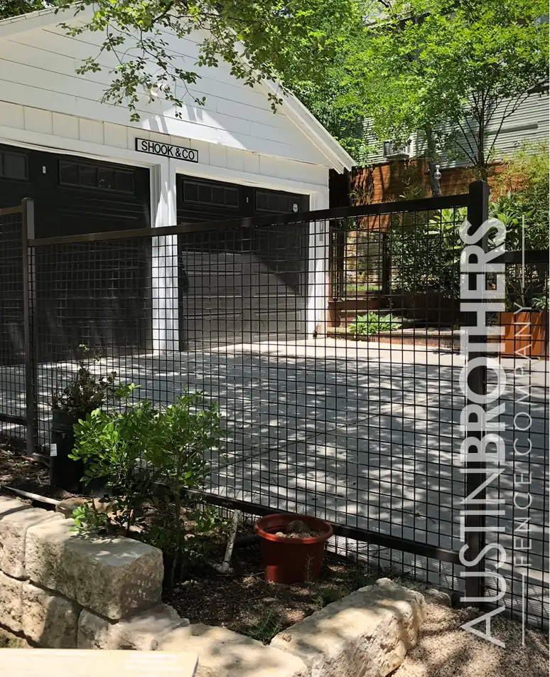 Iron bull panel fence closing off the driveway of an Austin home.
