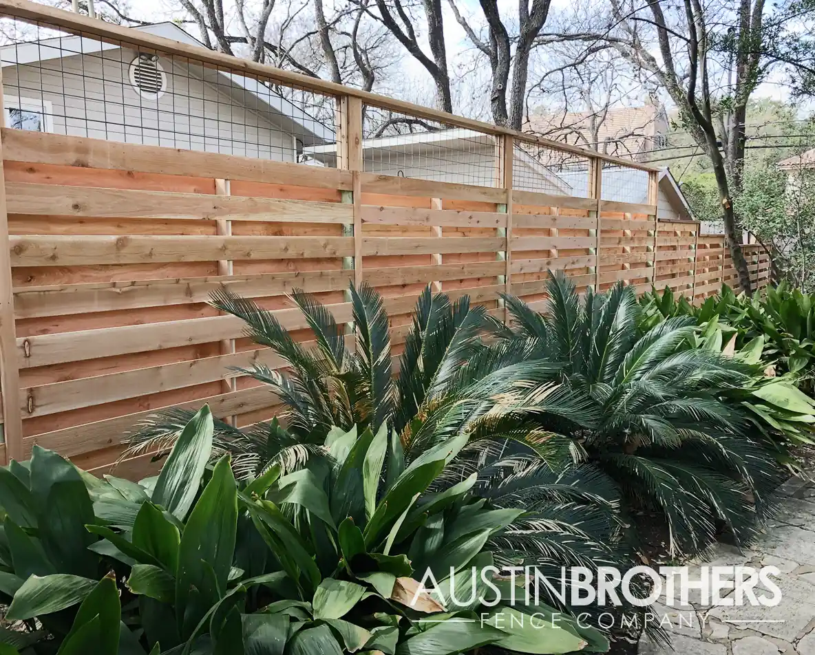 Horizontal wooden fence with bull panel on top.