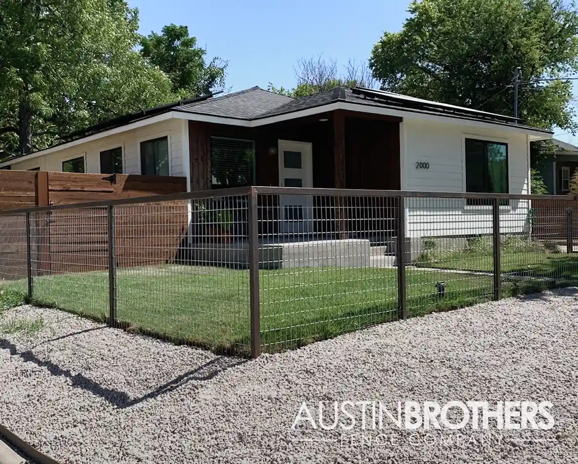 Steel bull panel fence enclosing the front yard of an Austin home.