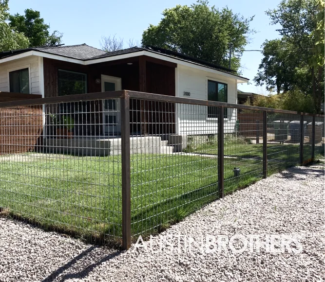 Iron bull panel fence closing off the front yard of an Austin home.