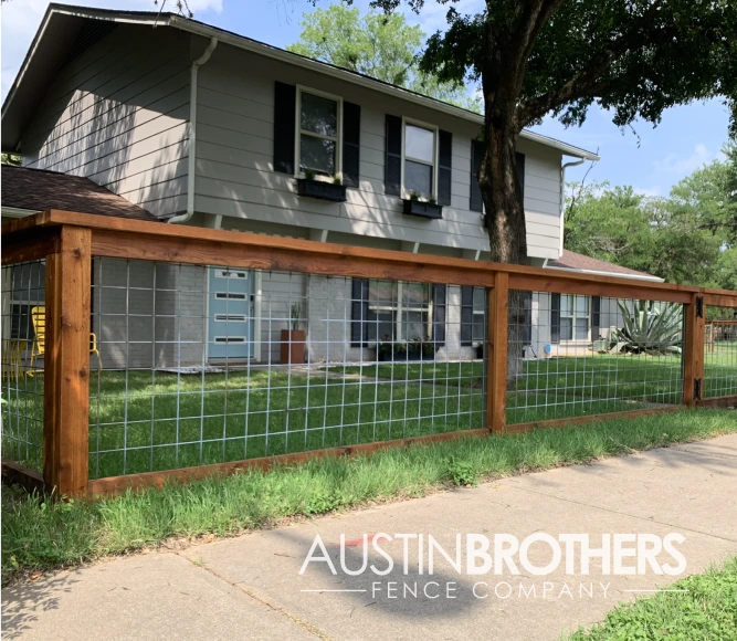 Wooden bull panel fence surrounding the front yard of a Texas home.