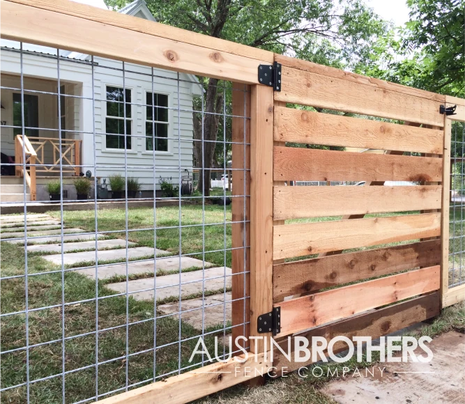 Wooden bull panel fence with a gate and black latch.