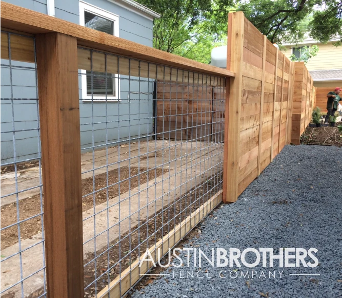 Wooden bull panel fence turning into a vertical wooden fence.