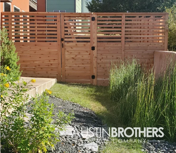 Horizontal wooden fence and gate with slats on the top half.