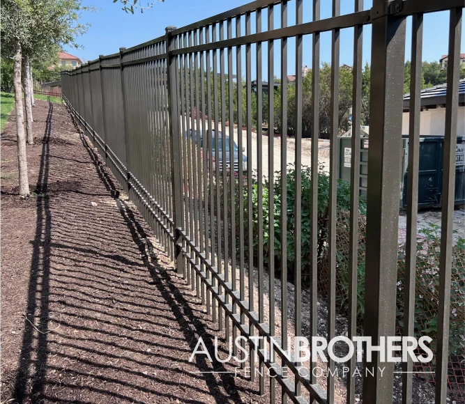 Iron fence running alongside a neighborhood street in the Texas Hill Country.