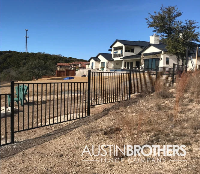 Black iron fence going up a hill.