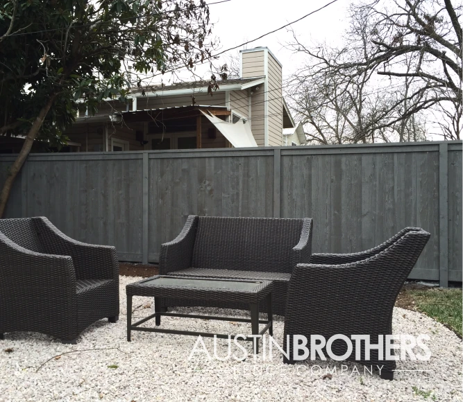 Capped black vertical wooden fence with wooden frames.