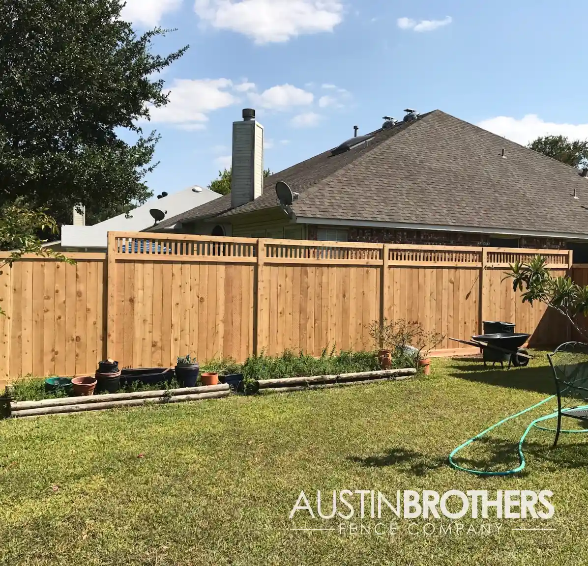 Capped vertical wooden fence running alongside an Austin, Texas backyard.