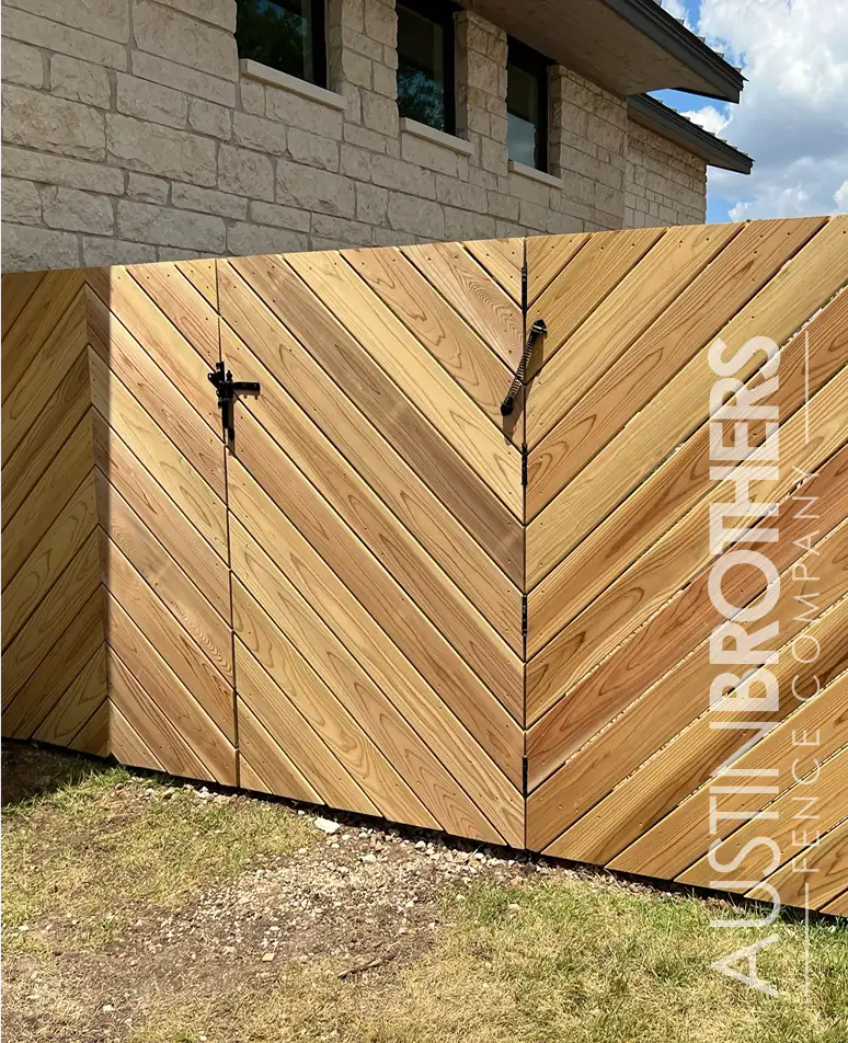 Angled wooden fence with a black steel gate latch.