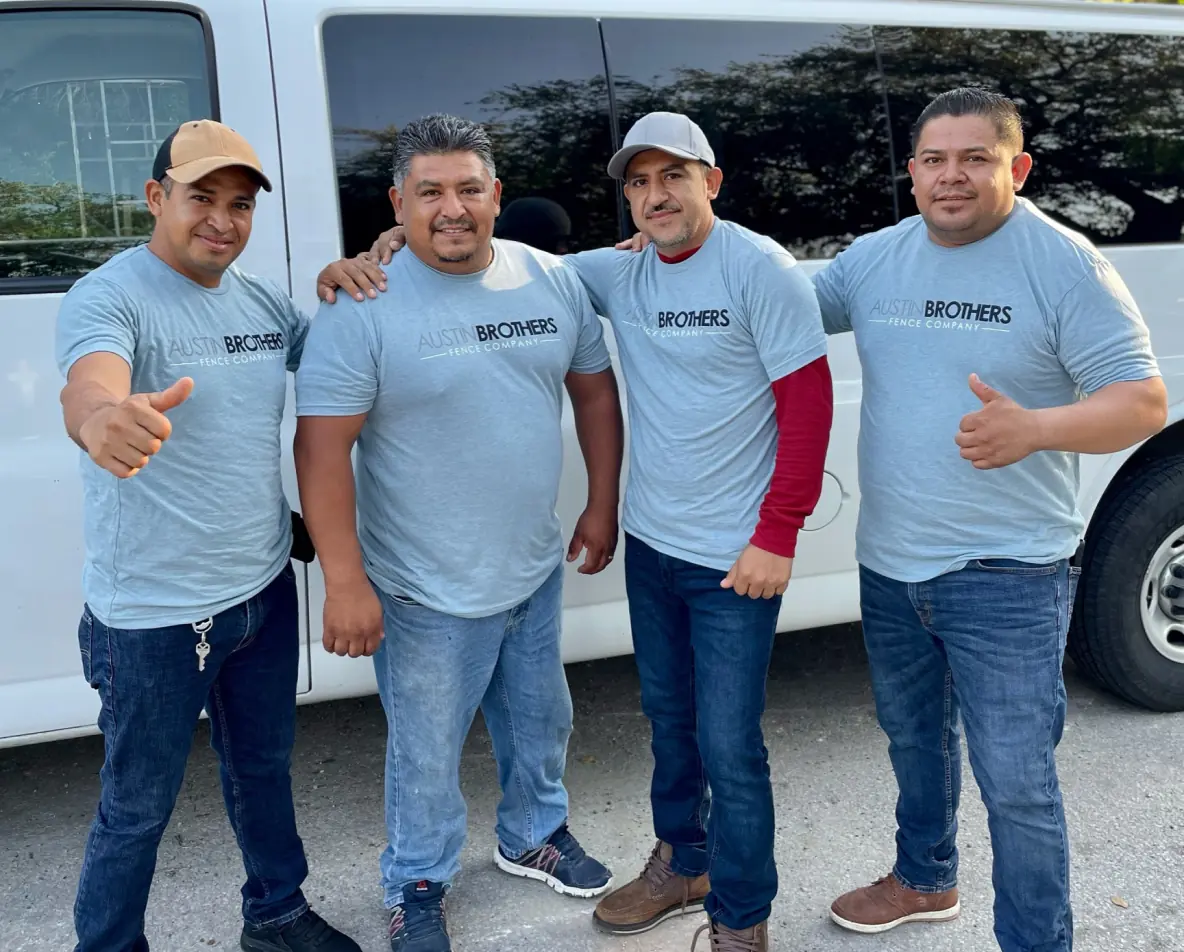Four Austin Brothers Fence Company team members posing in front of an installation van.