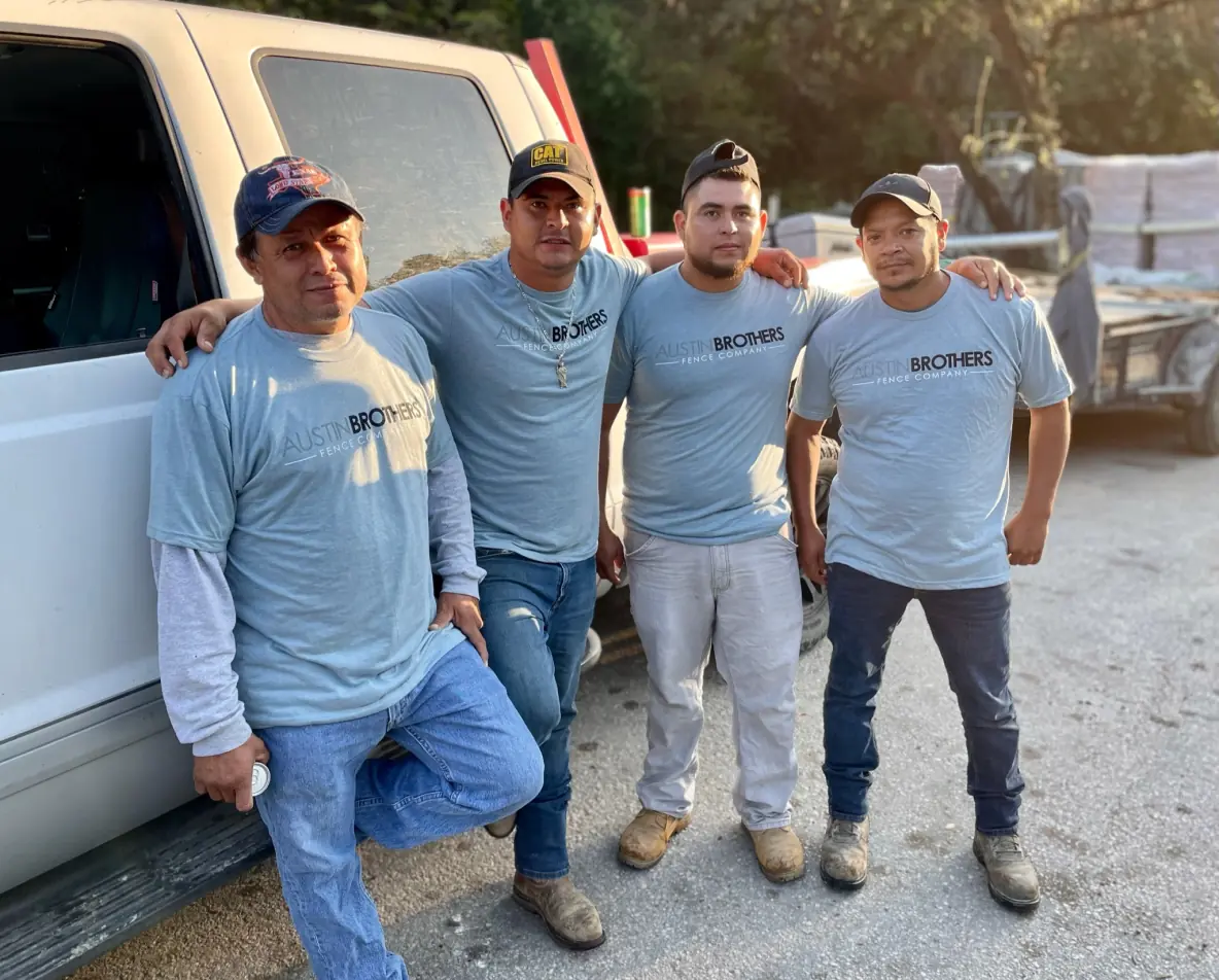 Four Austin Brothers Fence Company team members posing in front of a work truck.